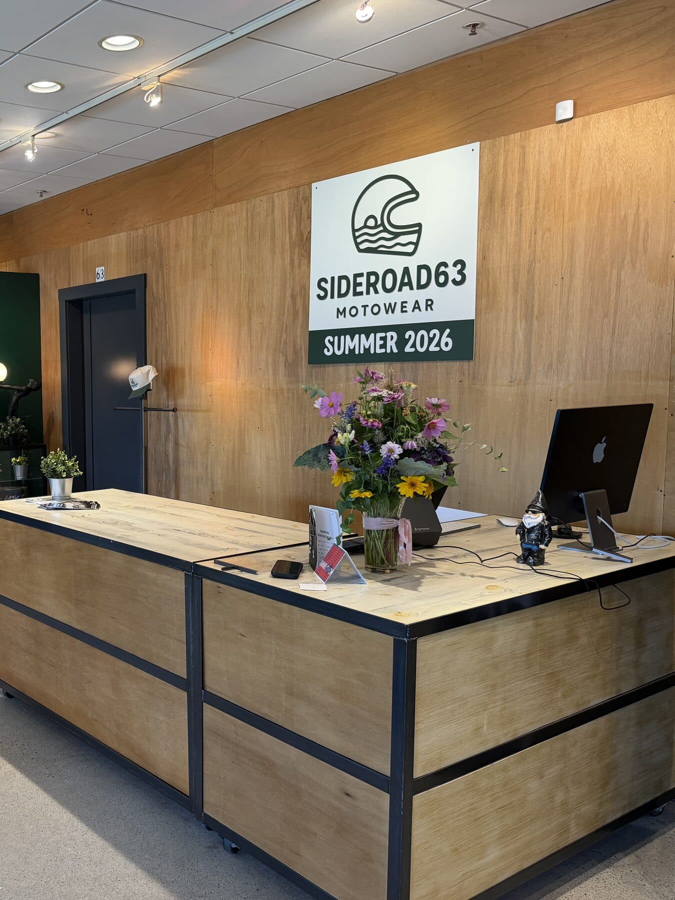 The counter at SIDEROAD63, under the shop sign on the plywood feature wall
