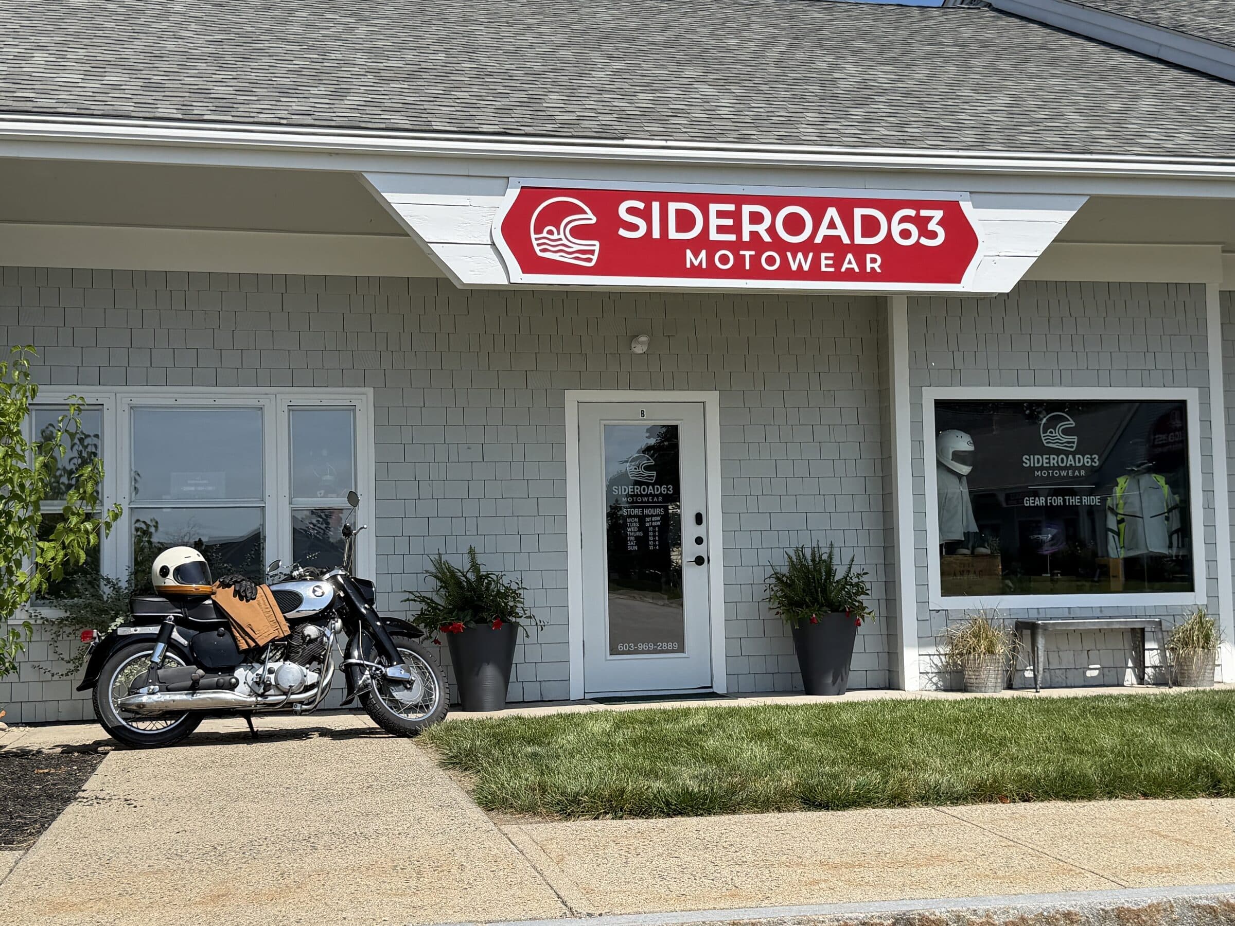 The SIDEROAD63 Motowear storefront on Lafayette Road, sign installed and a motorcycle parked outside